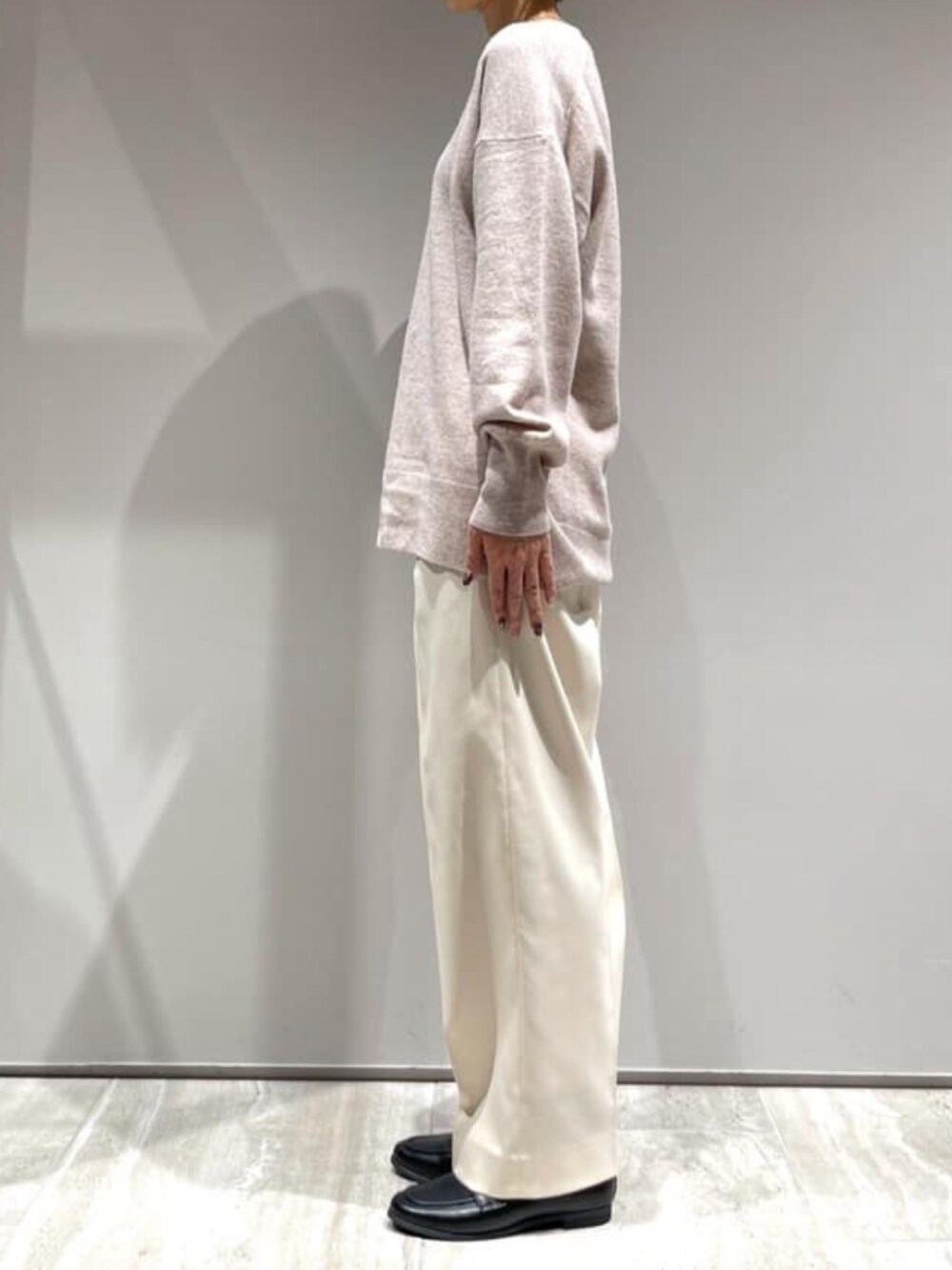 ホワイト系のその他パンツ、ブラウン系のショルダーバッグ、ベージュ系のニット/セーターを着用したレディースの冬コーディネートの5枚目の写真