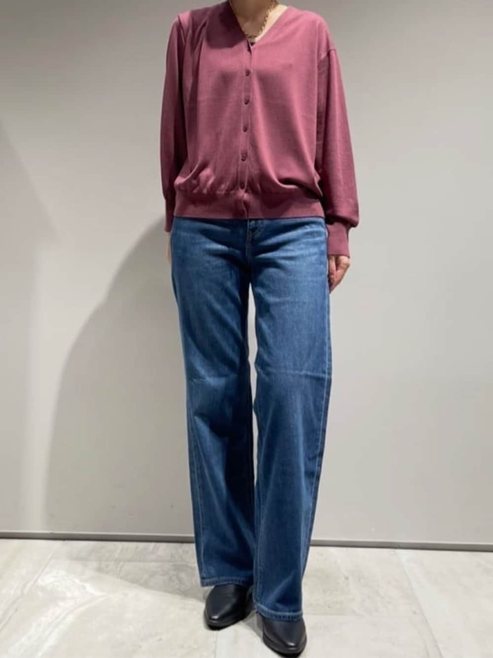 ブルー系のデニムパンツ、レッド系のカーディガン/ボレロ、ゴールド系のネックレスを着用したレディースの秋コーディネートの2枚目の写真