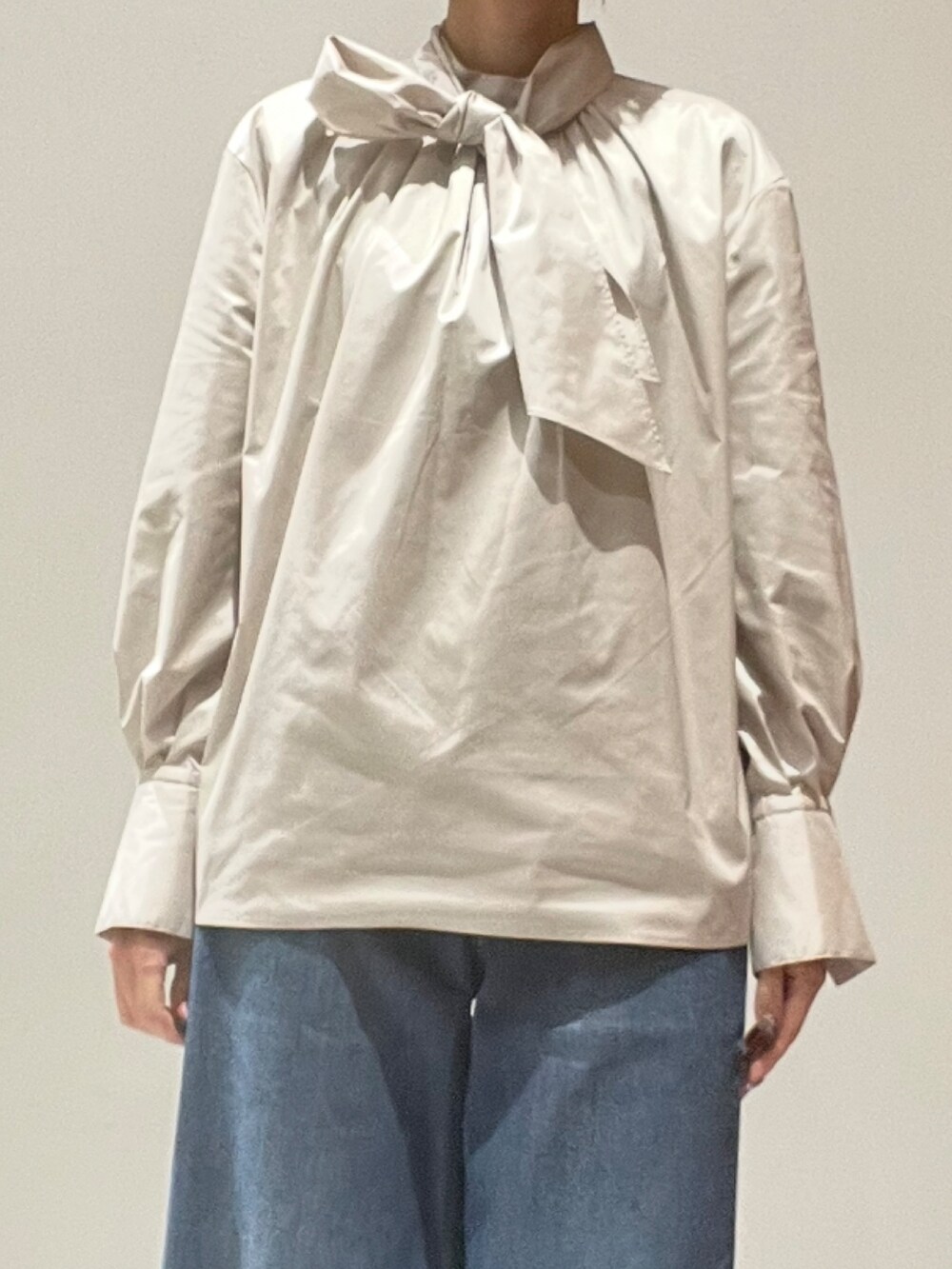 ブルー系のデニムパンツ、ブラウン系のショルダーバッグ、ブラウン系のテーラードジャケットを着用したレディースの秋コーディネートの5枚目の写真