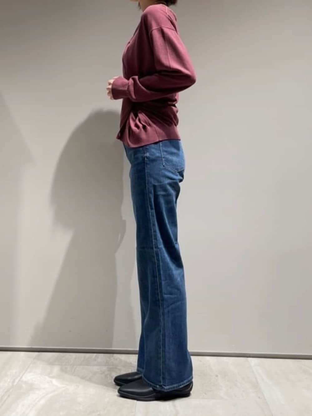 ブルー系のデニムパンツ、レッド系のカーディガン/ボレロ、ゴールド系のネックレスを着用したレディースの秋コーディネートの6枚目の写真