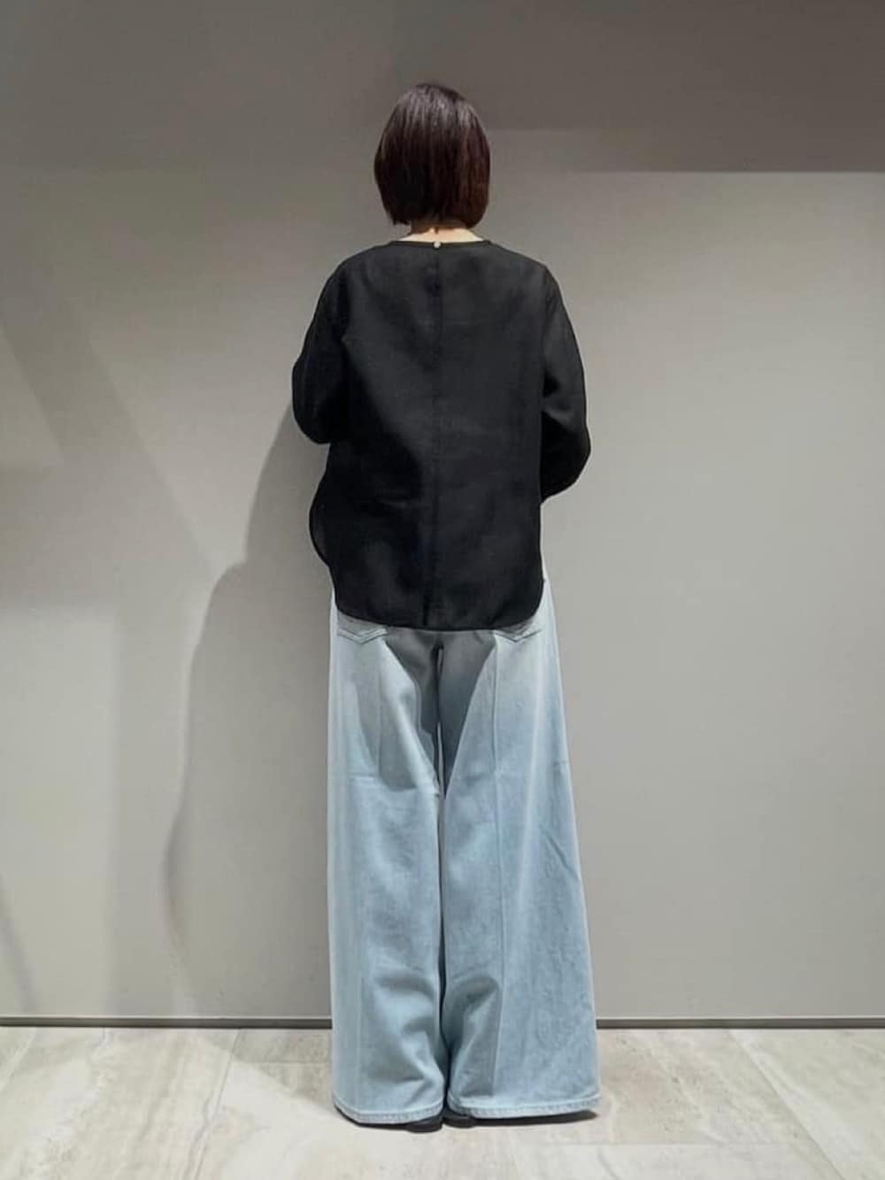 ブルー系のデニムパンツ、ブラック系のシャツ/ブラウス、ブラック系のベルトを着用したレディースの春コーディネートの7枚目の写真