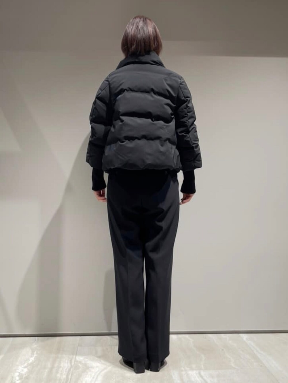 ブラック系のその他パンツ、ブラック系のダウンジャケット/コート、グレー系のニット/セーターを着用したレディースの冬コーディネートの6枚目の写真