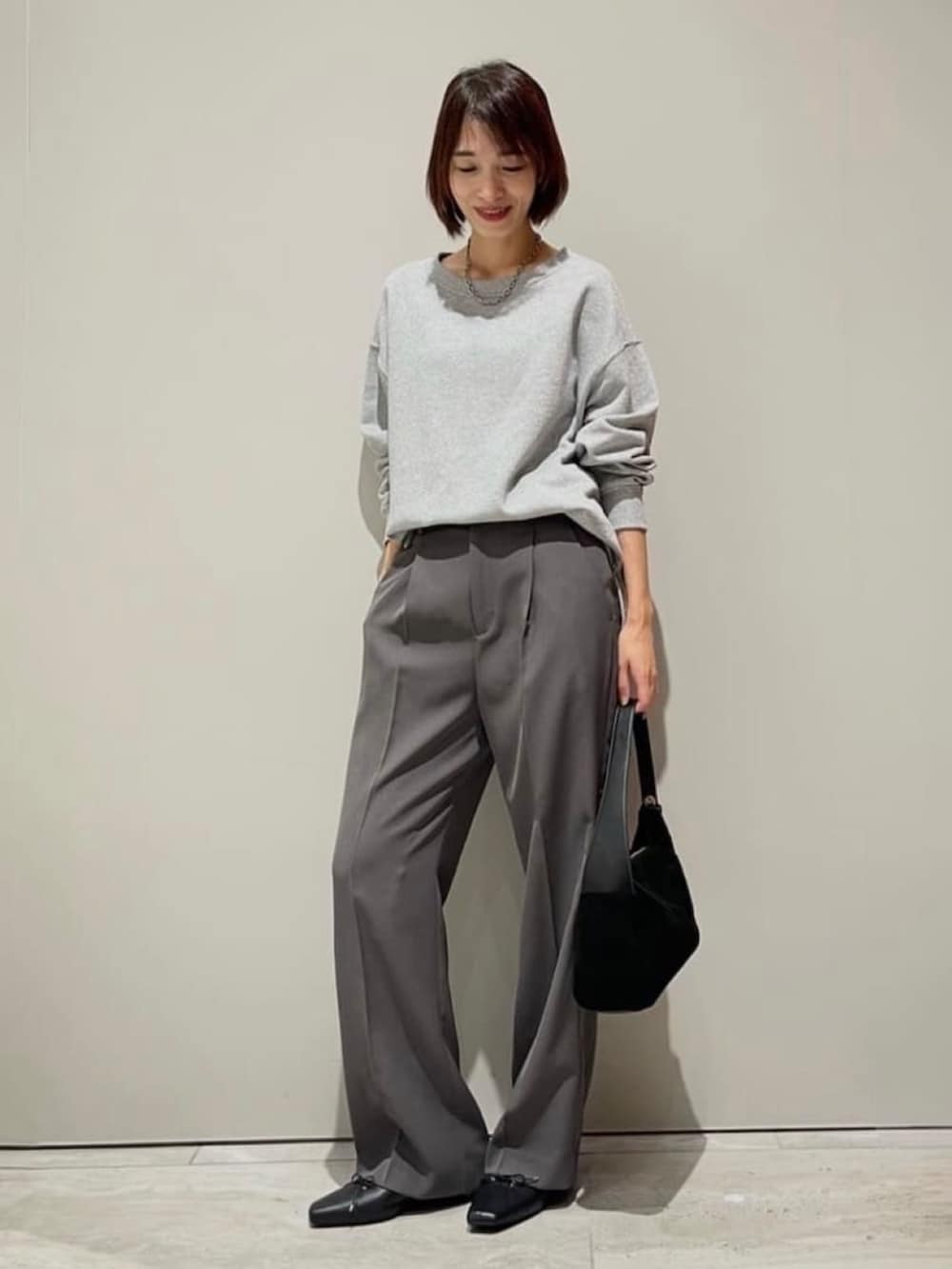 グレー系のその他パンツ、グレー系のTシャツ/カットソー、シルバー系のネックレスを着用したレディースの秋コーディネートの2枚目の写真