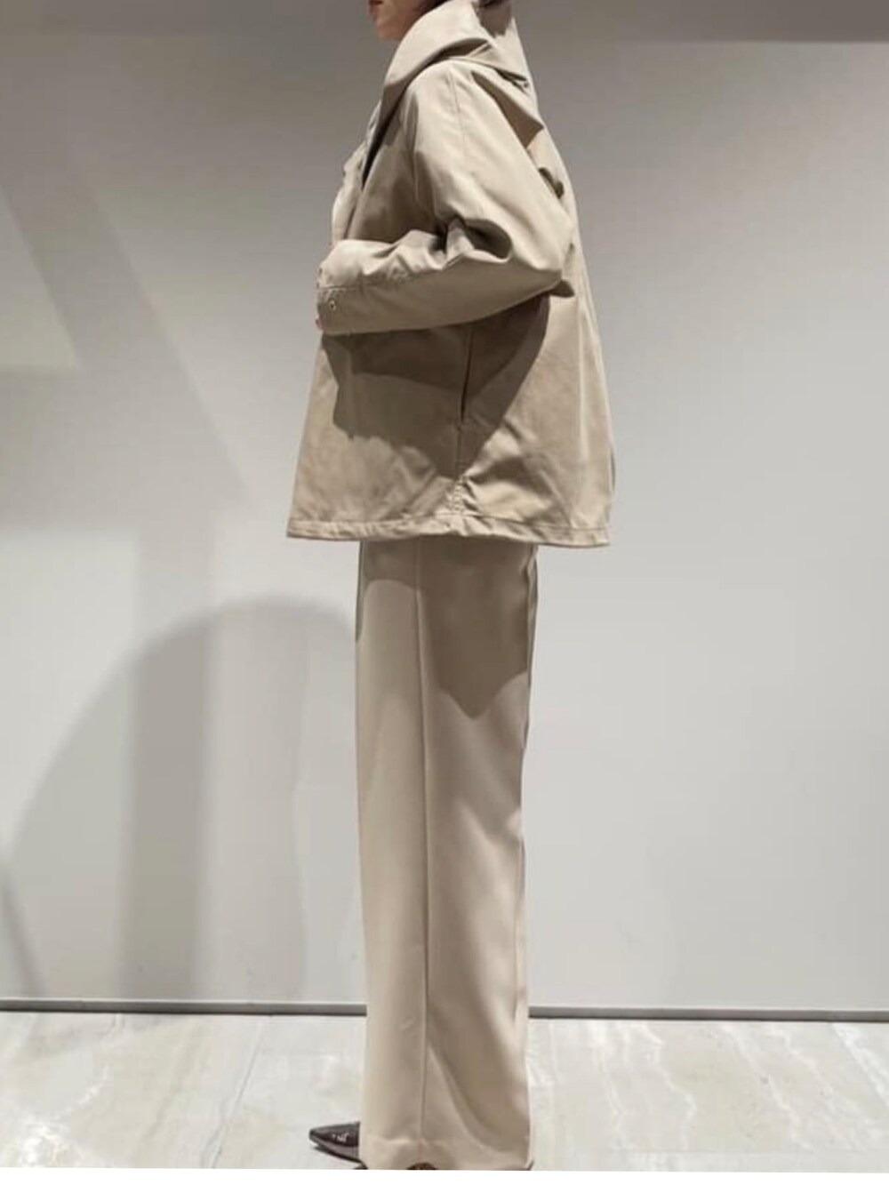 ベージュ系のブルゾン、ホワイト系のカーディガン/ボレロ、ベージュ系のその他パンツを着用したレディースの冬コーディネートの3枚目の写真
