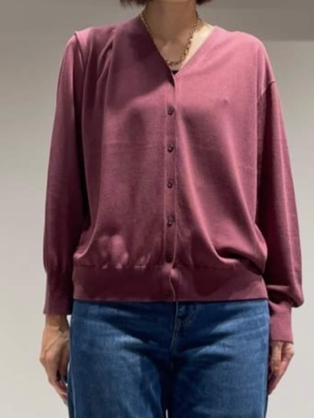 ブルー系のデニムパンツ、レッド系のカーディガン/ボレロ、ゴールド系のネックレスを着用したレディースの秋コーディネートの3枚目の写真