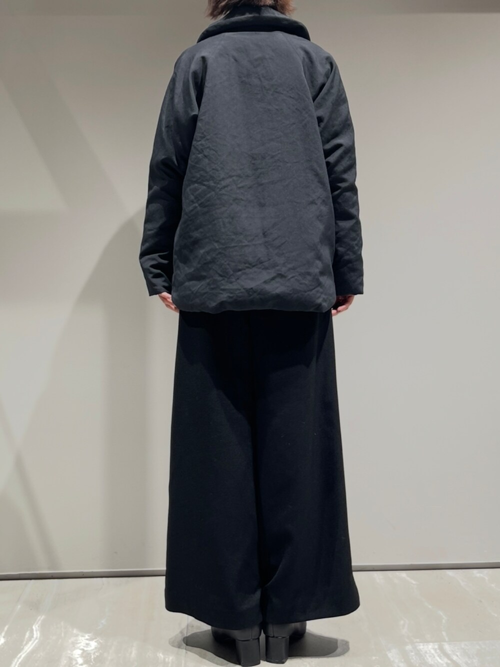 ブラック系のダウンジャケット/コート、ホワイト系のニット/セーター、ブラック系のその他パンツを着用したレディースの秋コーディネートの5枚目の写真