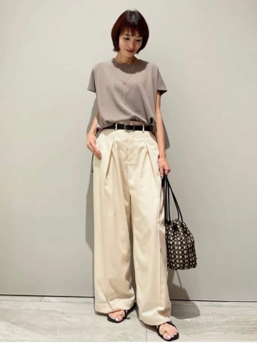 ホワイト系のその他パンツ、グレー系のニット/セーター、ブラック系のショルダーバッグを着用したレディースの春コーディネートの2枚目の写真