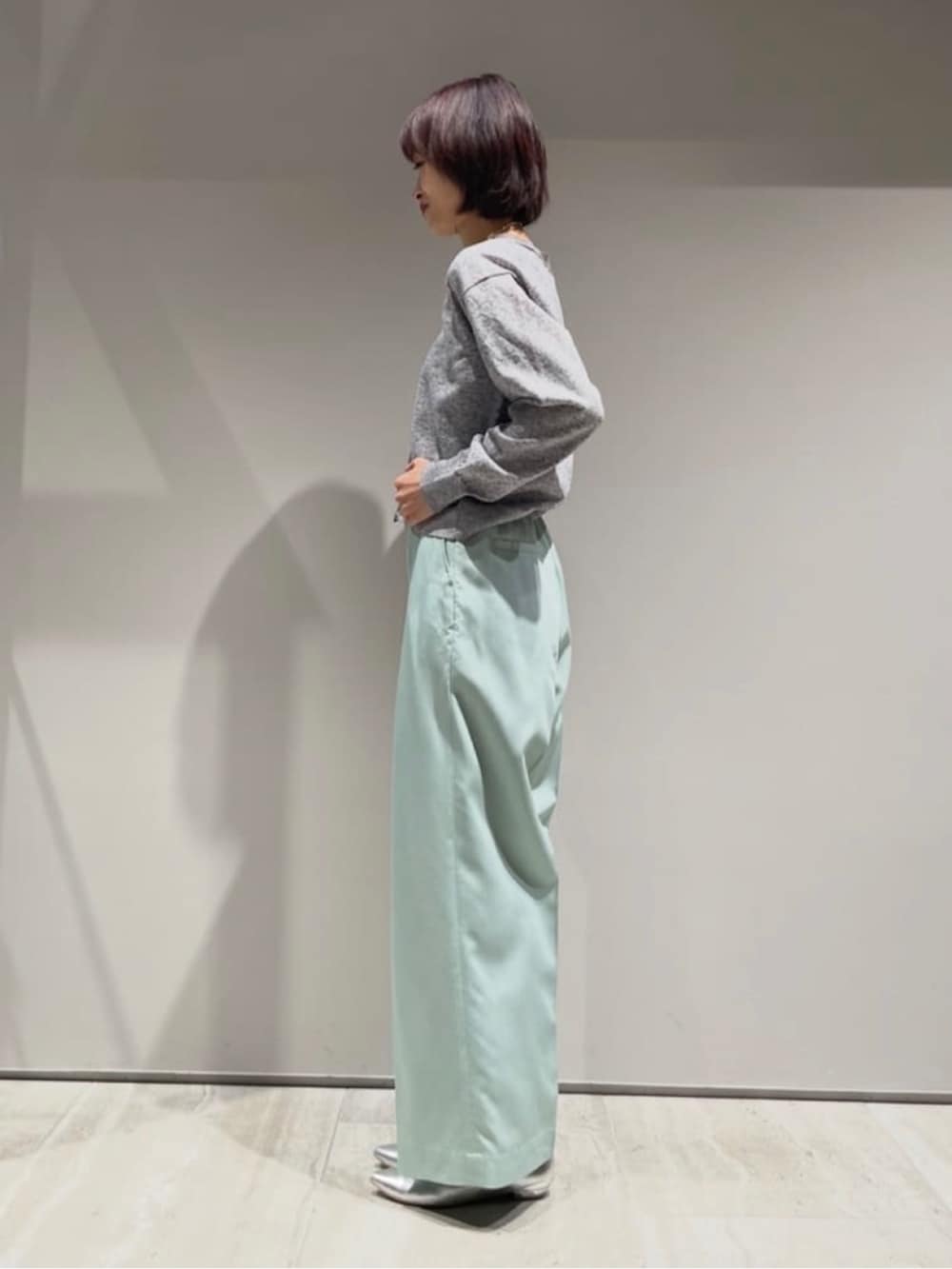 グリーン系のその他パンツ、グレー系のカーディガン/ボレロ、シルバー系のネックレスを着用したレディースの冬コーディネートの6枚目の写真