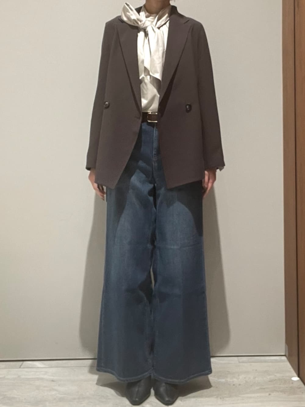 ブルー系のデニムパンツ、ブラウン系のショルダーバッグ、ブラウン系のテーラードジャケットを着用したレディースの秋コーディネートの2枚目の写真