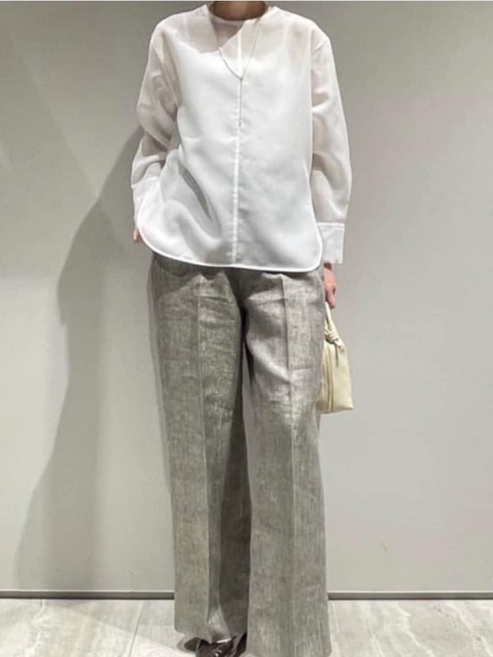 ベージュ系のその他パンツ、ホワイト系のシャツ/ブラウス、ゴールド系のネックレスを着用したレディースの春コーディネートの2枚目の写真