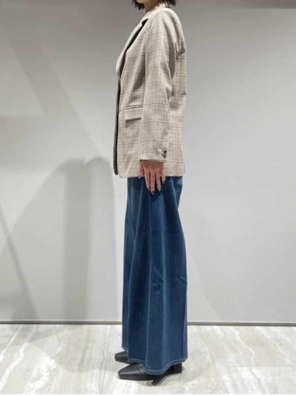 ブラウン系のニット/セーター、ベージュ系のテーラードジャケット、ブラウン系のショルダーバッグを着用したレディースの秋コーディネートの5枚目の写真