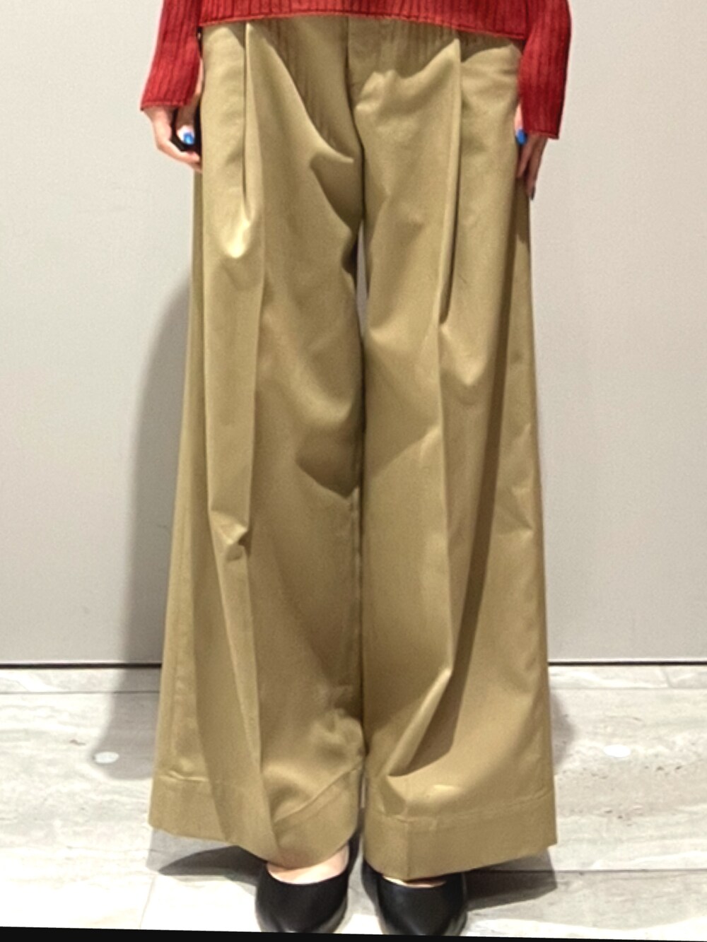 オレンジ系のニット/セーター、ベージュ系のその他パンツを着用したレディースの秋コーディネートの4枚目の写真