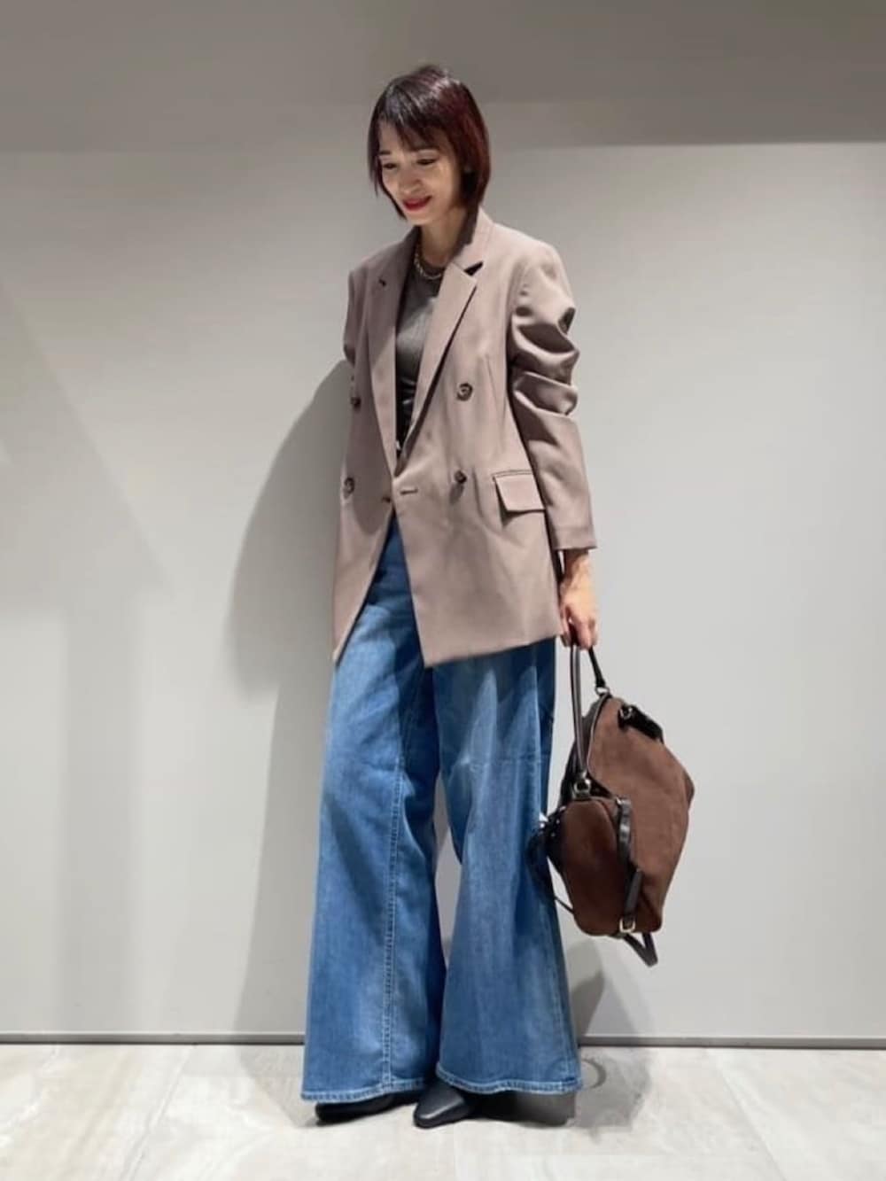 ブラウン系のテーラードジャケット、その他のTシャツ/カットソー、ブルー系のデニムパンツを着用したレディースの秋コーディネートの2枚目の写真