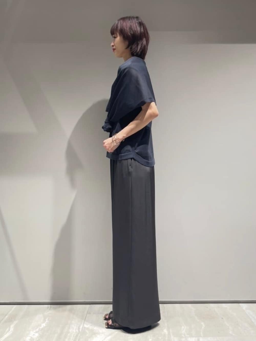 グレー系のその他パンツ、グレー系のニット/セーター、シルバー系のバングル/リストバンドを着用したレディースの春コーディネートの2枚目の写真