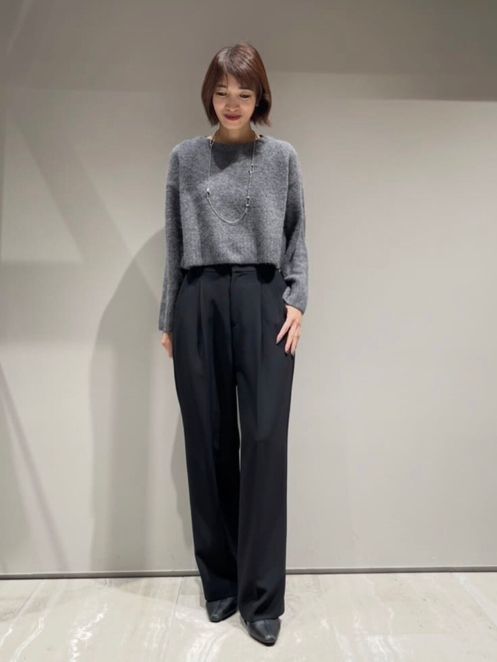 ブラック系のその他パンツ、ブラック系のダウンジャケット/コート、グレー系のニット/セーターを着用したレディースの冬コーディネートの7枚目の写真