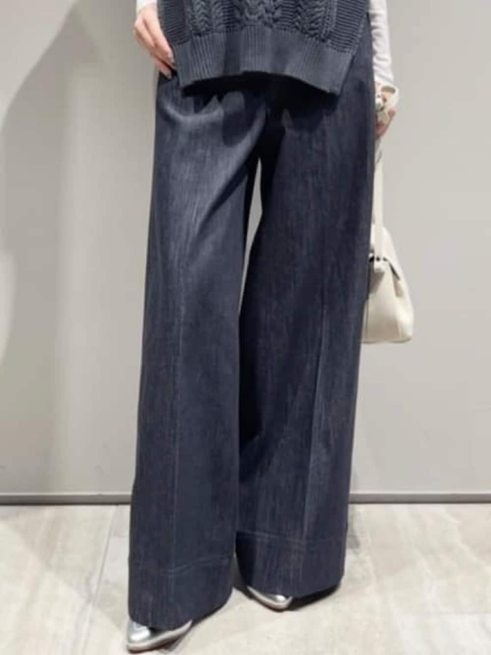 ブルー系のデニムパンツ、ホワイト系のショルダーバッグ、ホワイト系のTシャツ/カットソーを着用したレディースの冬コーディネートの4枚目の写真