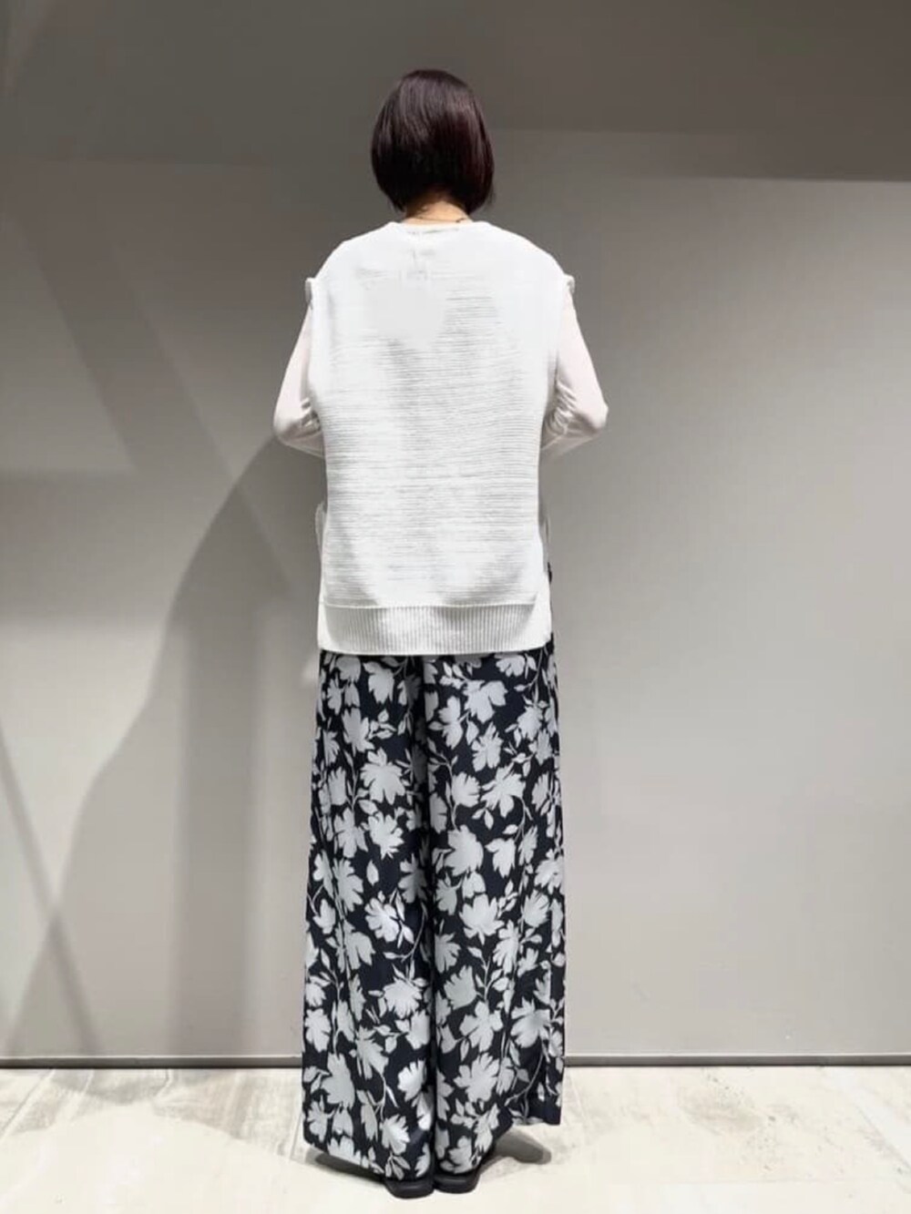 ホワイト系のTシャツ/カットソー、グレー系のその他パンツ、ホワイト系のニット/セーターを着用したレディースの冬コーディネートの6枚目の写真