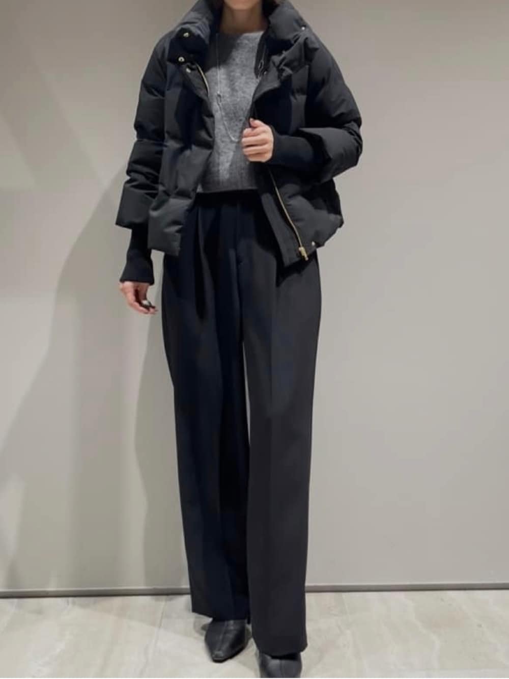 ブラック系のその他パンツ、ブラック系のダウンジャケット/コート、グレー系のニット/セーターを着用したレディースの冬コーディネートの3枚目の写真