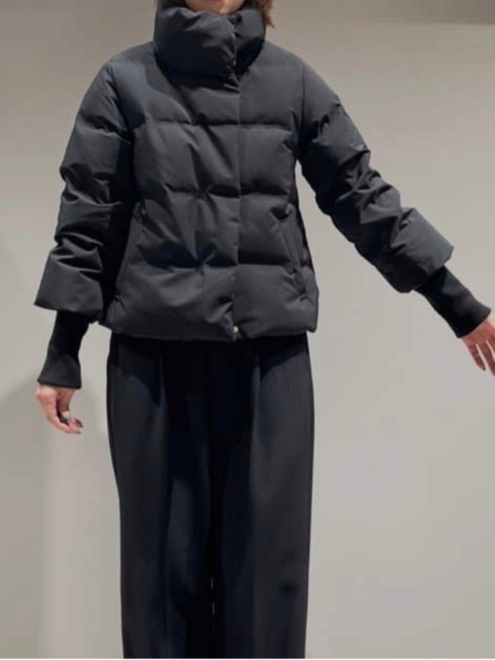 ブラック系のその他パンツ、ブラック系のダウンジャケット/コート、グレー系のニット/セーターを着用したレディースの冬コーディネートの4枚目の写真