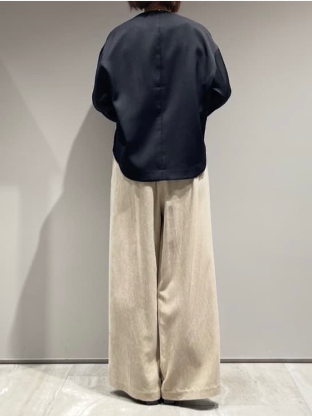 ベージュ系のその他パンツ、ブラック系のニット/セーター、ブラック系のブルゾンを着用したレディースの秋コーディネートの6枚目の写真