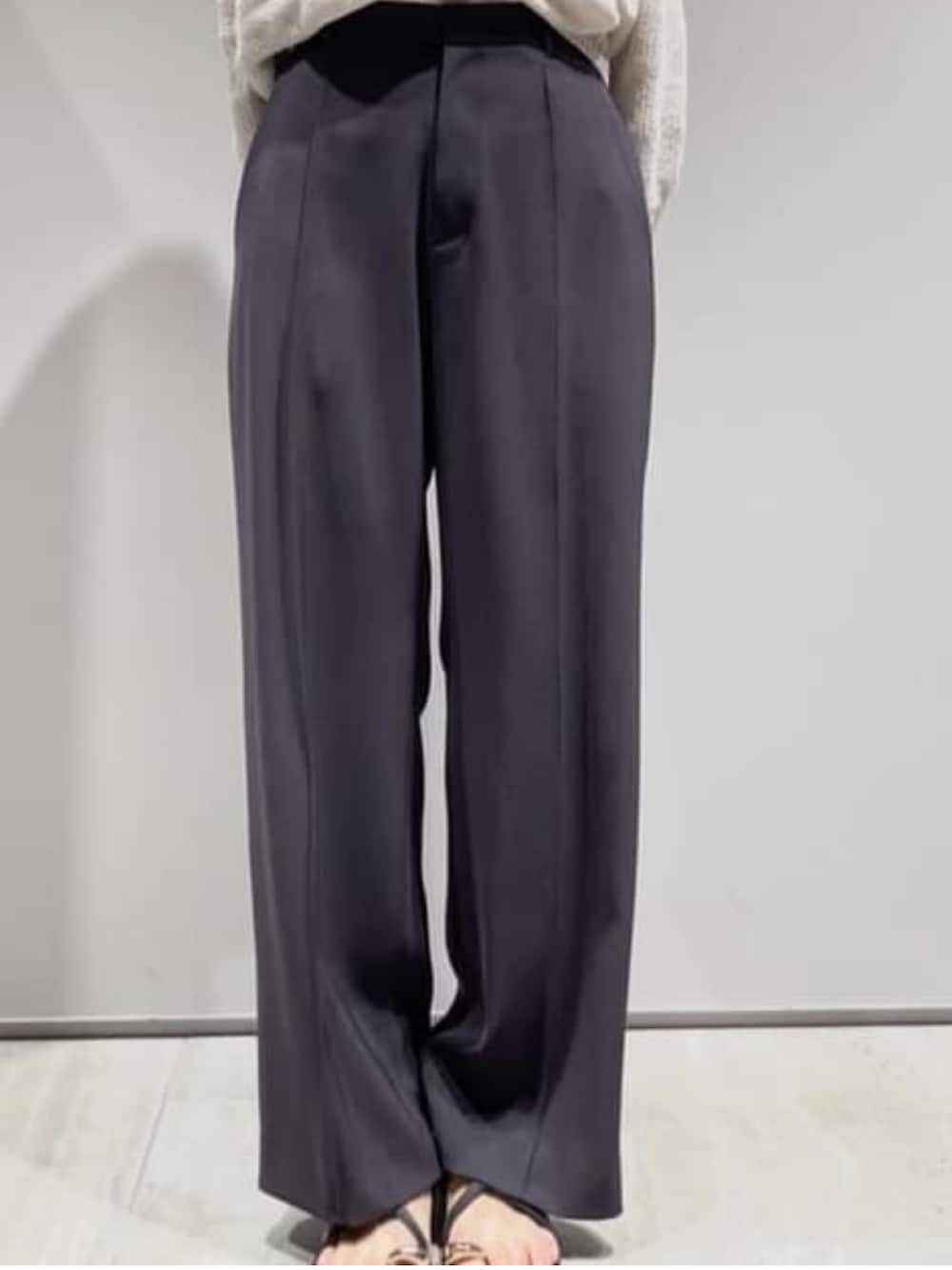 グレー系のその他パンツ、ベージュ系のニット/セーター、ホワイト系のタンクトップを着用したレディースの春コーディネートの3枚目の写真