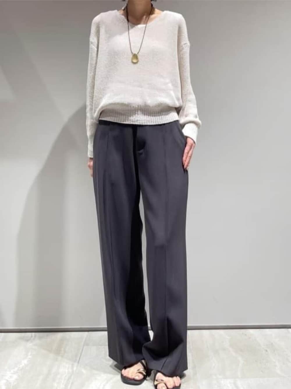 グレー系のその他パンツ、ベージュ系のニット/セーター、ホワイト系のタンクトップを着用したレディースの春コーディネートの4枚目の写真