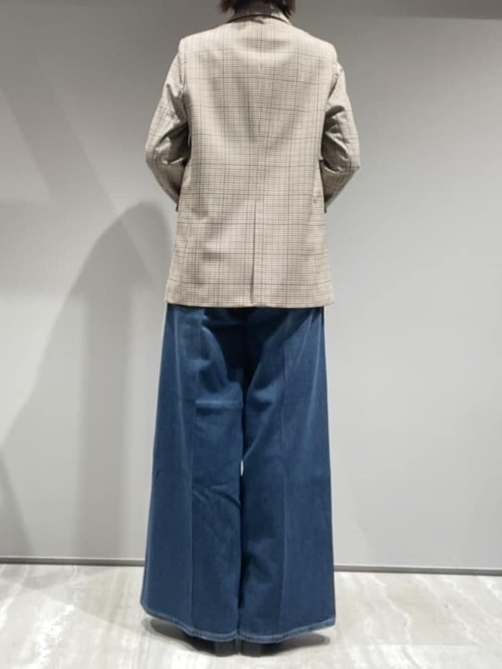 ブラウン系のニット/セーター、ベージュ系のテーラードジャケット、ブラウン系のショルダーバッグを着用したレディースの秋コーディネートの6枚目の写真