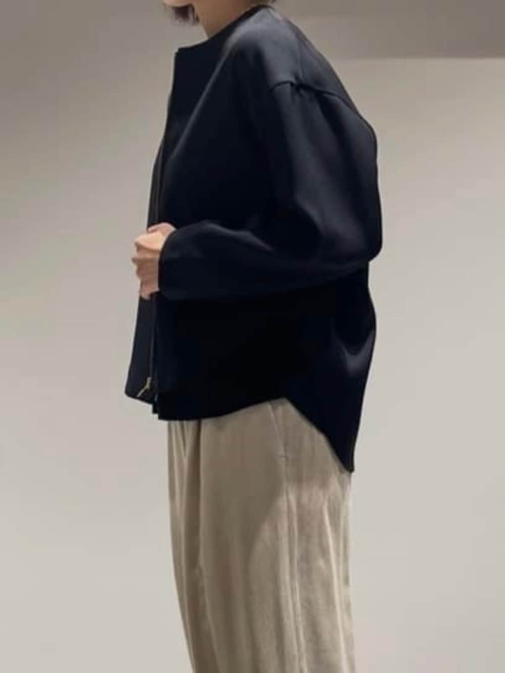 ベージュ系のその他パンツ、ブラック系のニット/セーター、ブラック系のブルゾンを着用したレディースの秋コーディネートの4枚目の写真