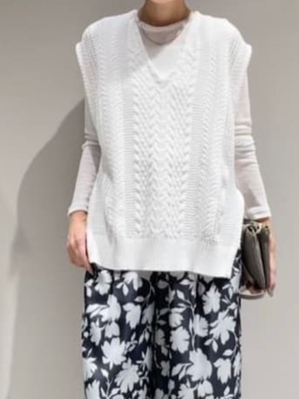 ホワイト系のTシャツ/カットソー、グレー系のその他パンツ、ホワイト系のニット/セーターを着用したレディースの冬コーディネートの2枚目の写真