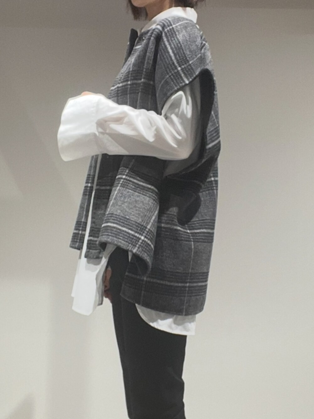 グリーン系のショルダーバッグ、その他のポンチョ、ホワイト系のシャツ/ブラウスを着用したレディースの秋コーディネートの3枚目の写真