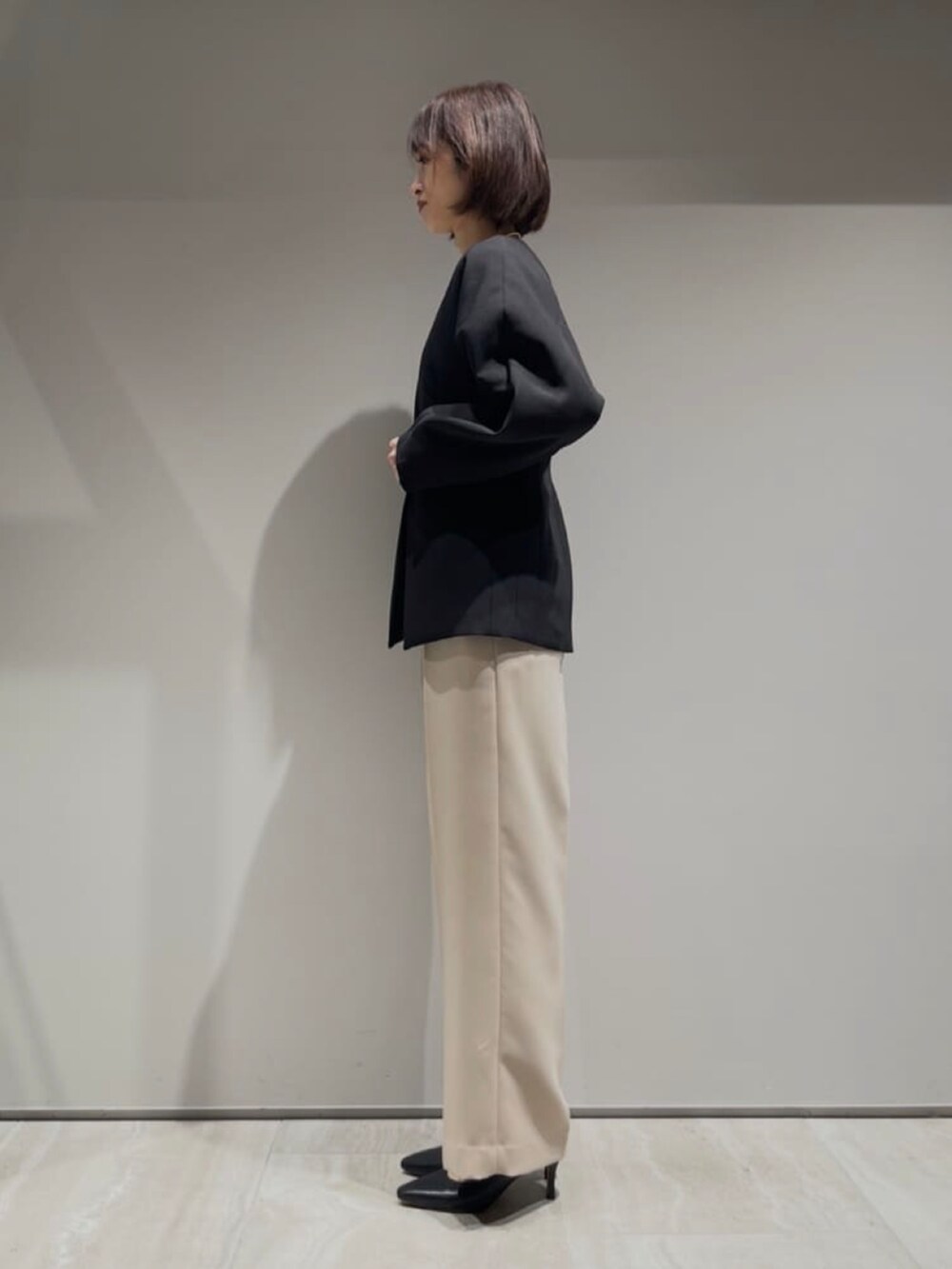 ホワイト系のシャツ/ブラウス、ベージュ系のその他パンツ、ブラック系のテーラードジャケットを着用したレディースの冬コーディネートの6枚目の写真