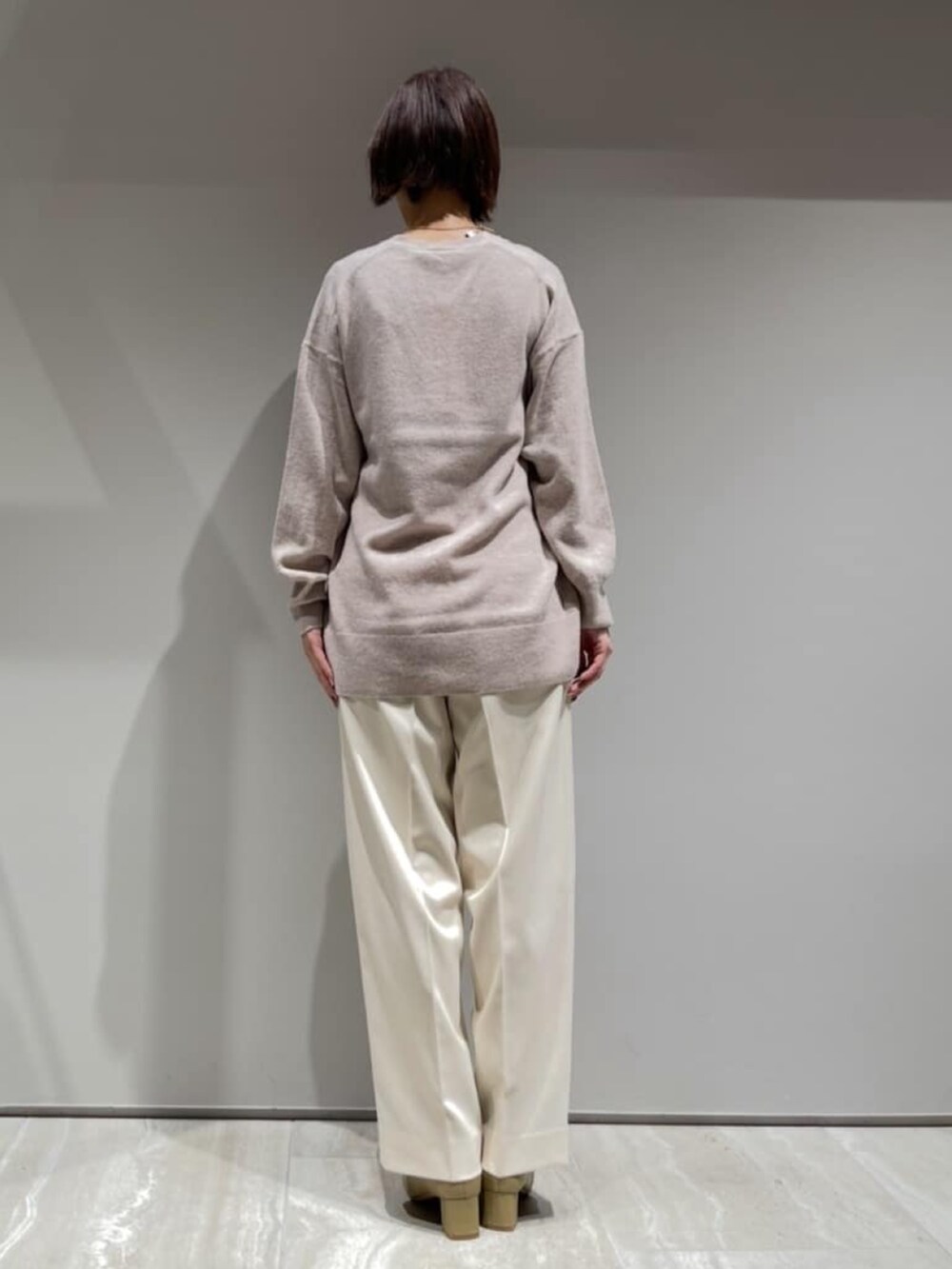 ホワイト系のその他パンツ、ブラウン系のショルダーバッグ、ベージュ系のニット/セーターを着用したレディースの冬コーディネートの6枚目の写真