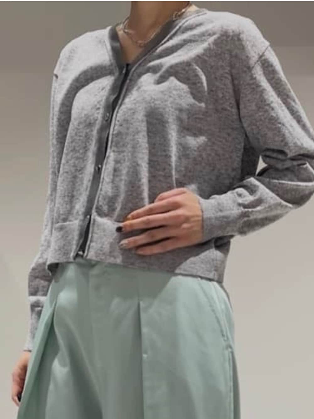 グリーン系のその他パンツ、グレー系のカーディガン/ボレロ、シルバー系のネックレスを着用したレディースの冬コーディネートの4枚目の写真