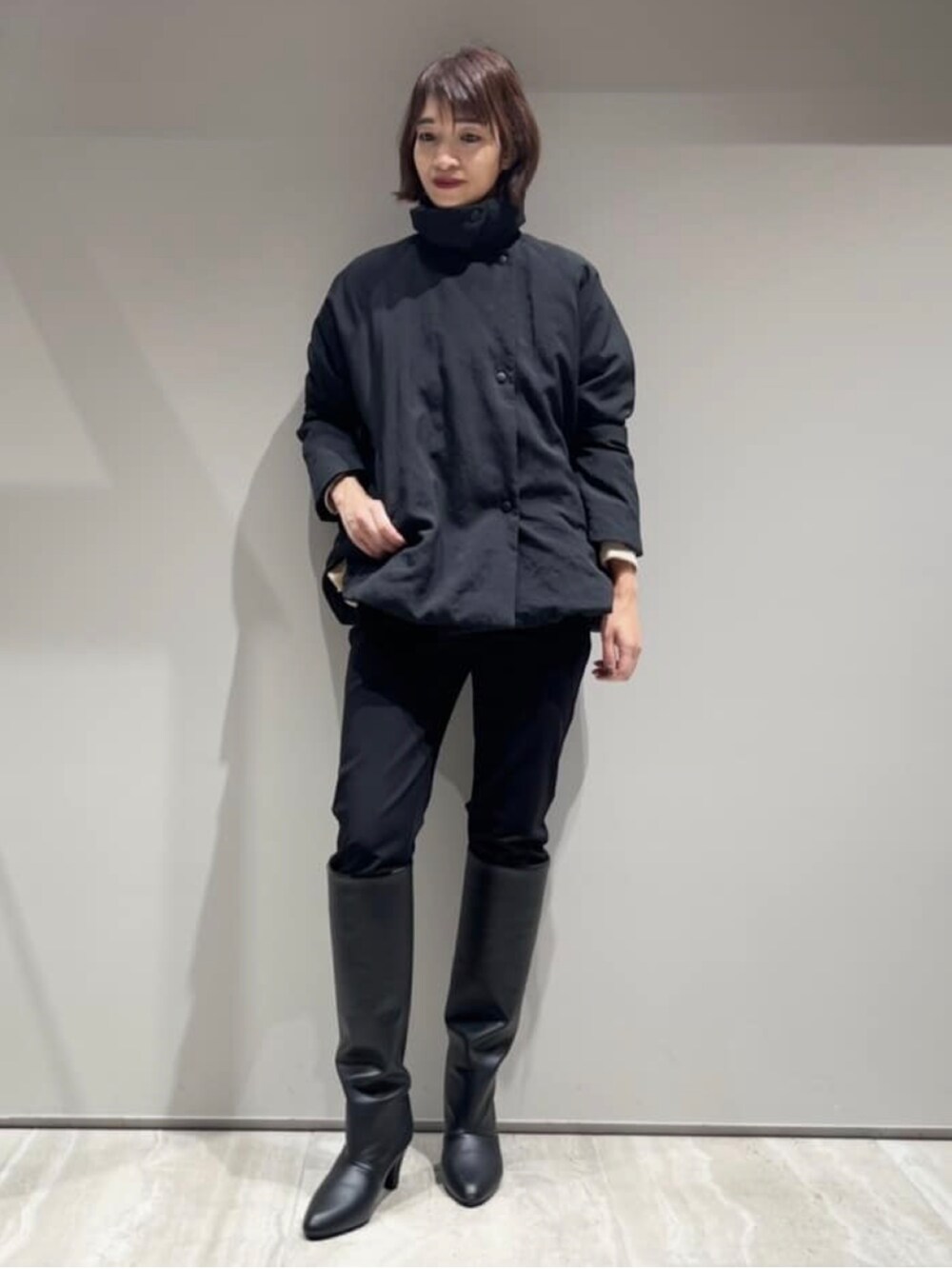 ブラック系のその他パンツ、ブラック系のダウンジャケット/コート、ベージュ系のスウェットを着用したレディースの冬コーディネートの3枚目の写真