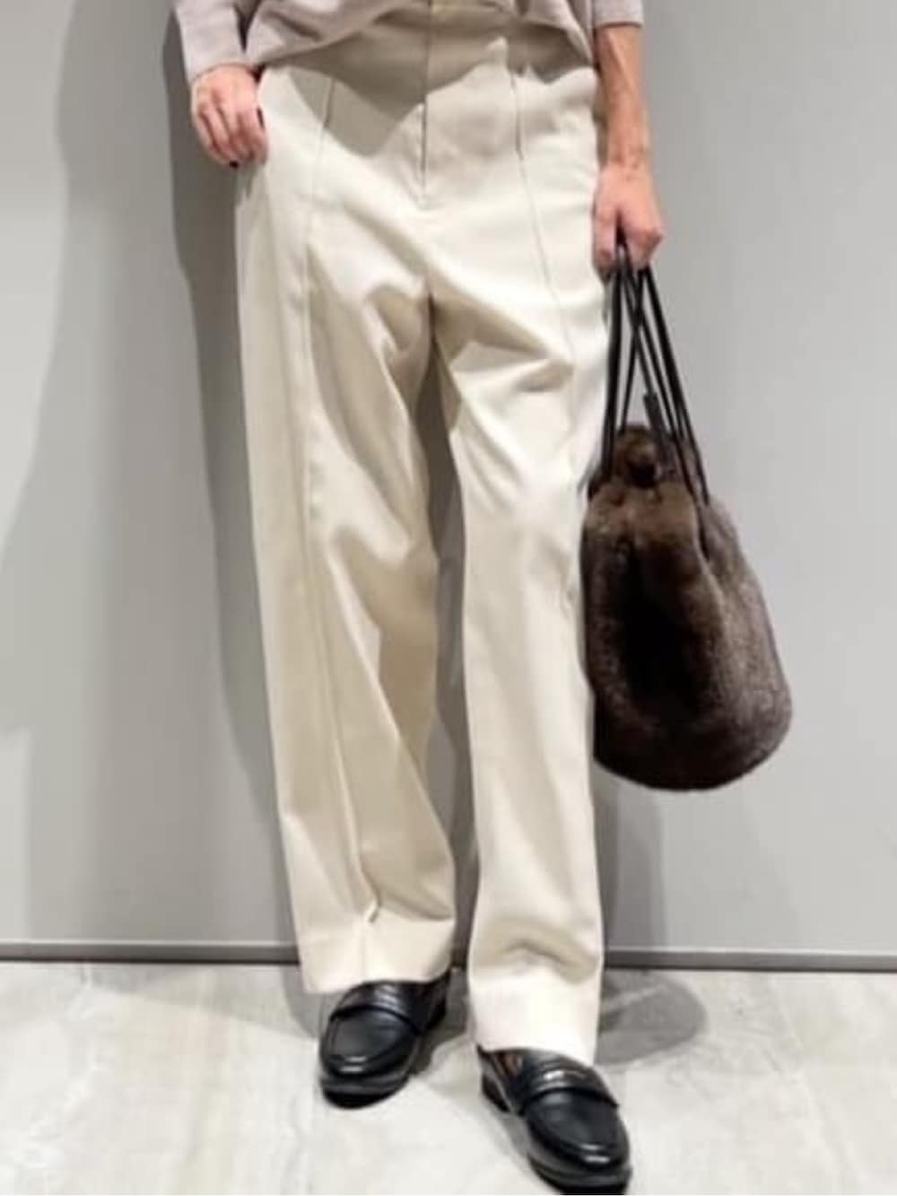 ホワイト系のその他パンツ、ブラウン系のショルダーバッグ、ベージュ系のニット/セーターを着用したレディースの冬コーディネートの4枚目の写真