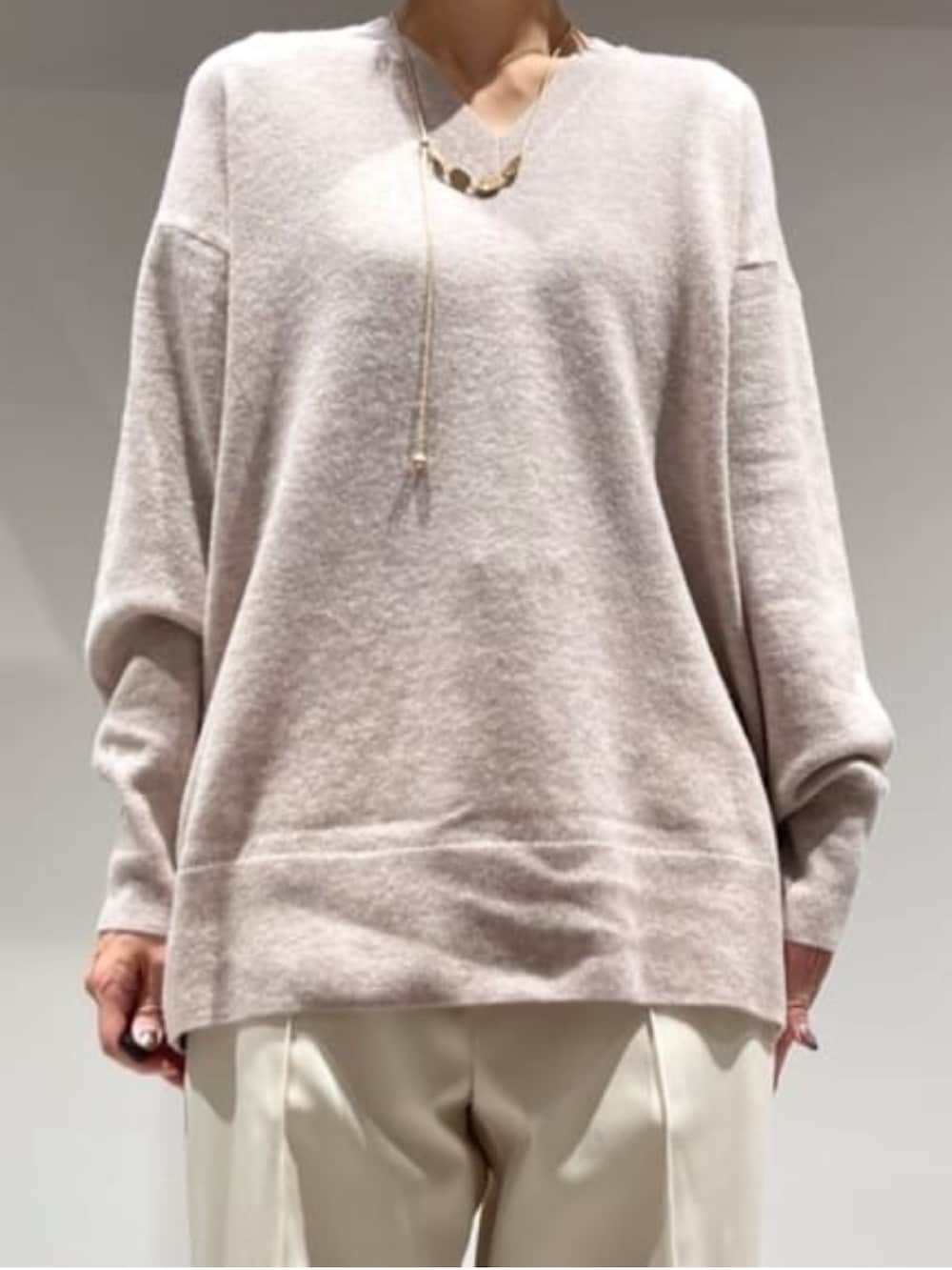 ホワイト系のその他パンツ、ブラウン系のショルダーバッグ、ベージュ系のニット/セーターを着用したレディースの冬コーディネートの3枚目の写真