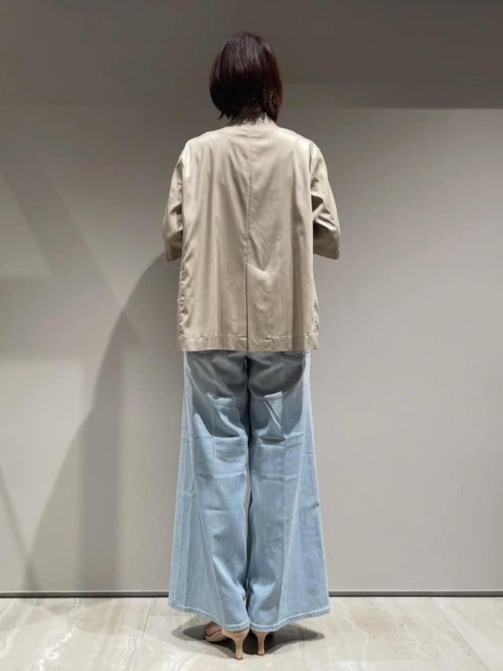 ベージュ系のテーラードジャケット、ホワイト系のTシャツ/カットソー、ブルー系のデニムパンツを着用したレディースの春コーディネートの4枚目の写真