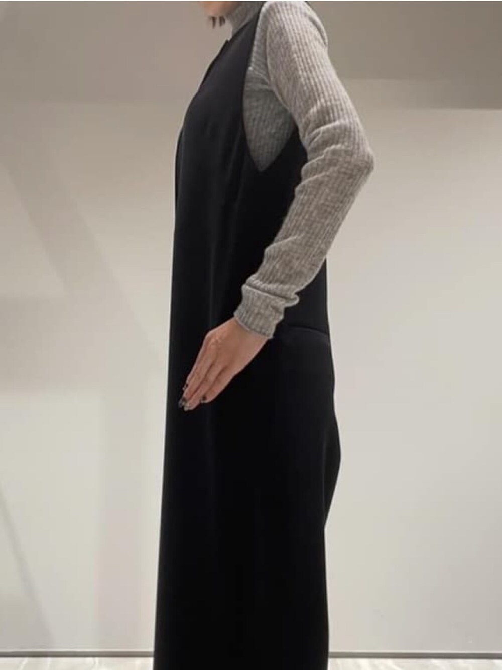 ブラック系のつなぎ/オールインワン、グレー系のニット/セーターを着用したレディースの秋コーディネートの2枚目の写真