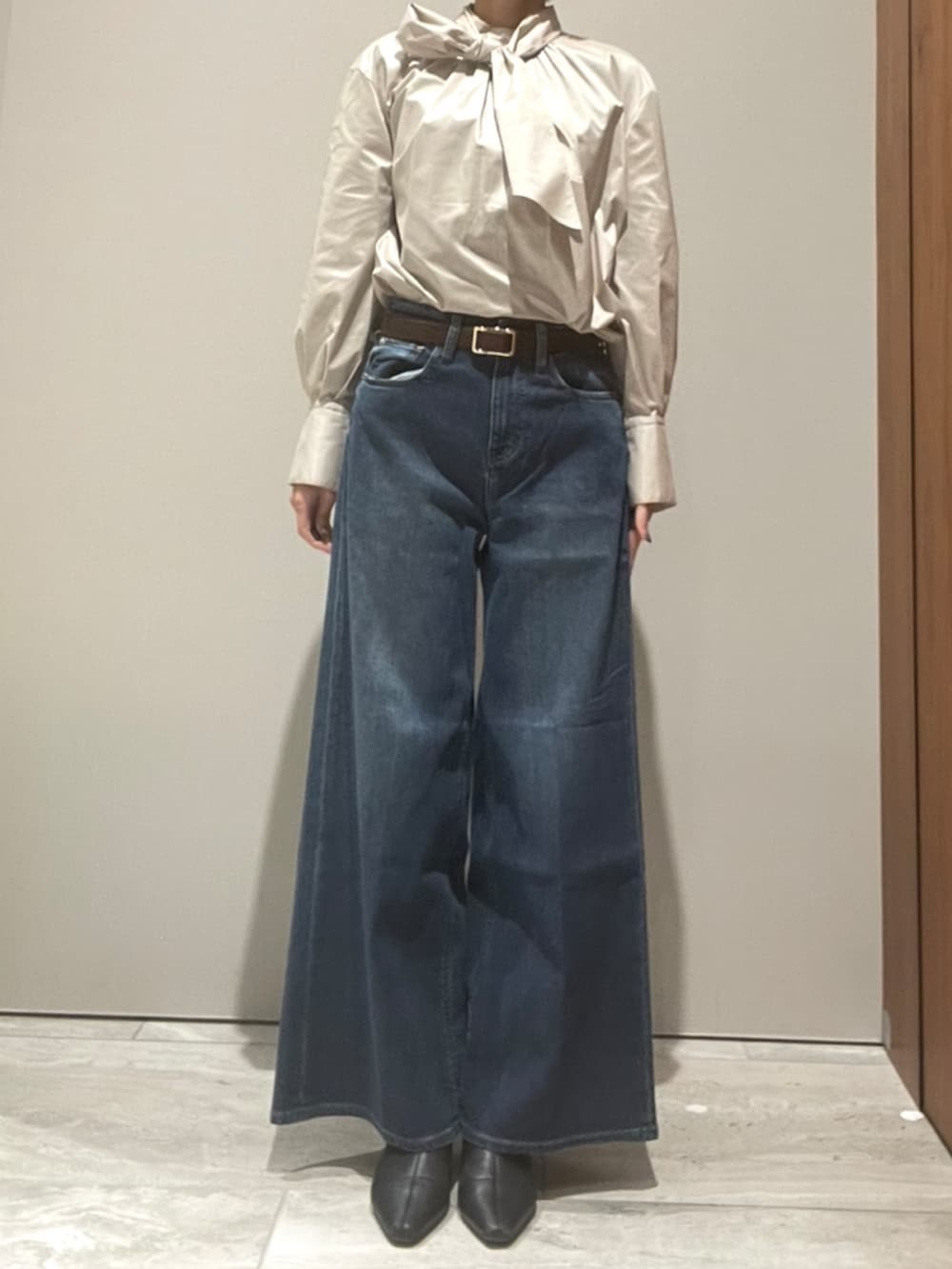 ブルー系のデニムパンツ、ブラウン系のショルダーバッグ、ブラウン系のテーラードジャケットを着用したレディースの秋コーディネートの8枚目の写真