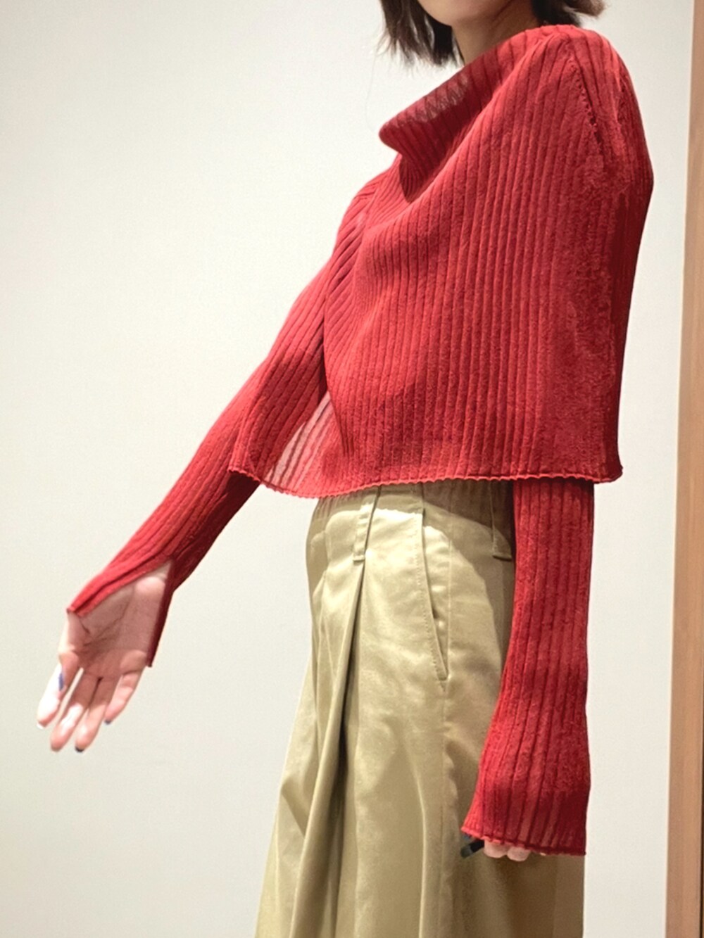 オレンジ系のニット/セーター、ベージュ系のその他パンツを着用したレディースの秋コーディネートの3枚目の写真