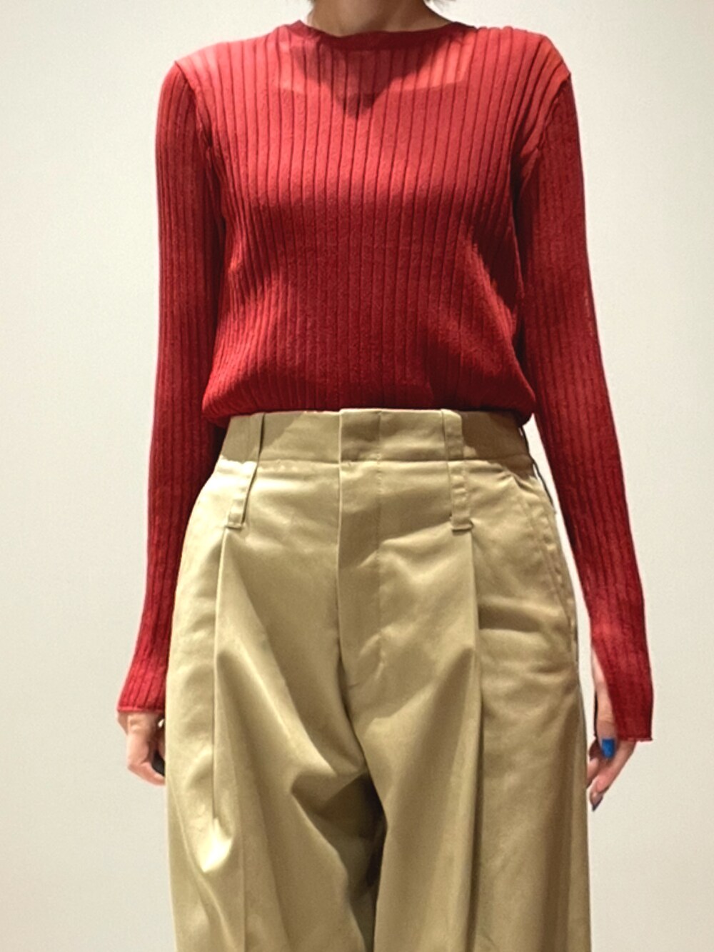 オレンジ系のニット/セーター、ベージュ系のその他パンツを着用したレディースの秋コーディネートの2枚目の写真