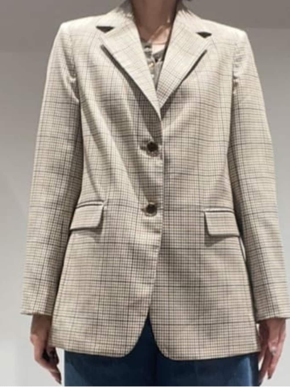 ブラウン系のニット/セーター、ベージュ系のテーラードジャケット、ブラウン系のショルダーバッグを着用したレディースの秋コーディネートの4枚目の写真