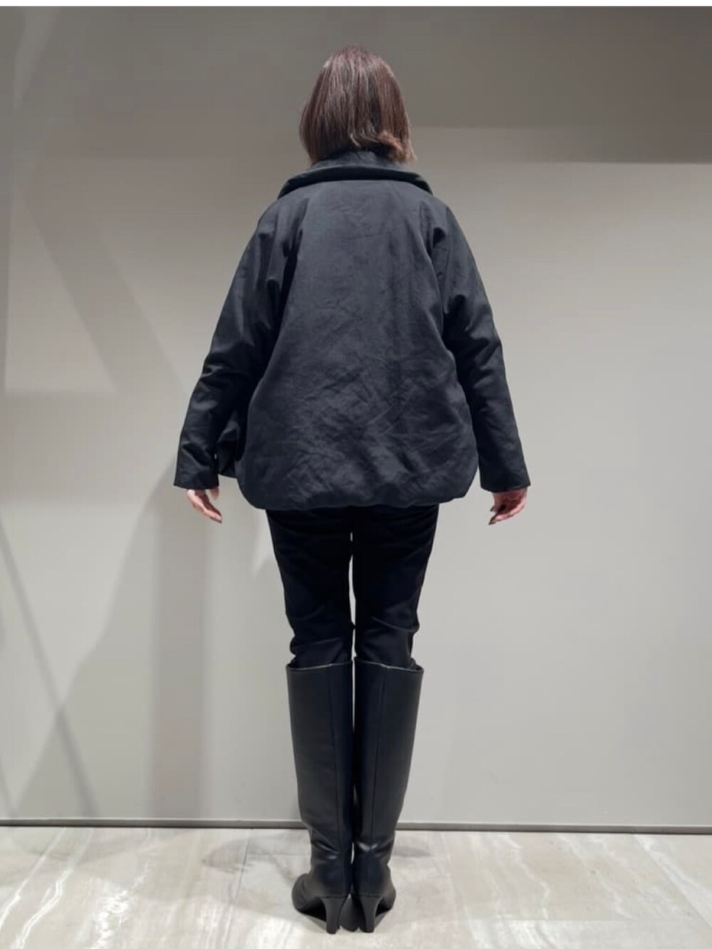 ブラック系のその他パンツ、ブラック系のダウンジャケット/コート、ベージュ系のスウェットを着用したレディースの冬コーディネートの5枚目の写真