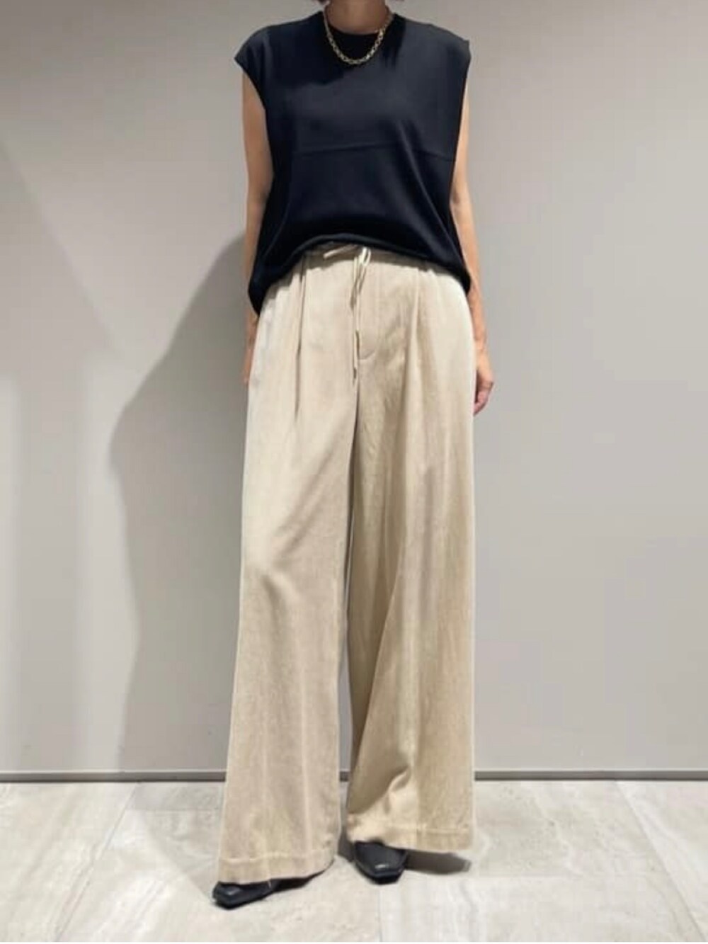 ベージュ系のその他パンツ、ブラック系のニット/セーター、ブラック系のブルゾンを着用したレディースの秋コーディネートの7枚目の写真