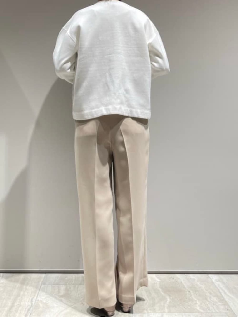 ベージュ系のブルゾン、ホワイト系のカーディガン/ボレロ、ベージュ系のその他パンツを着用したレディースの冬コーディネートの7枚目の写真