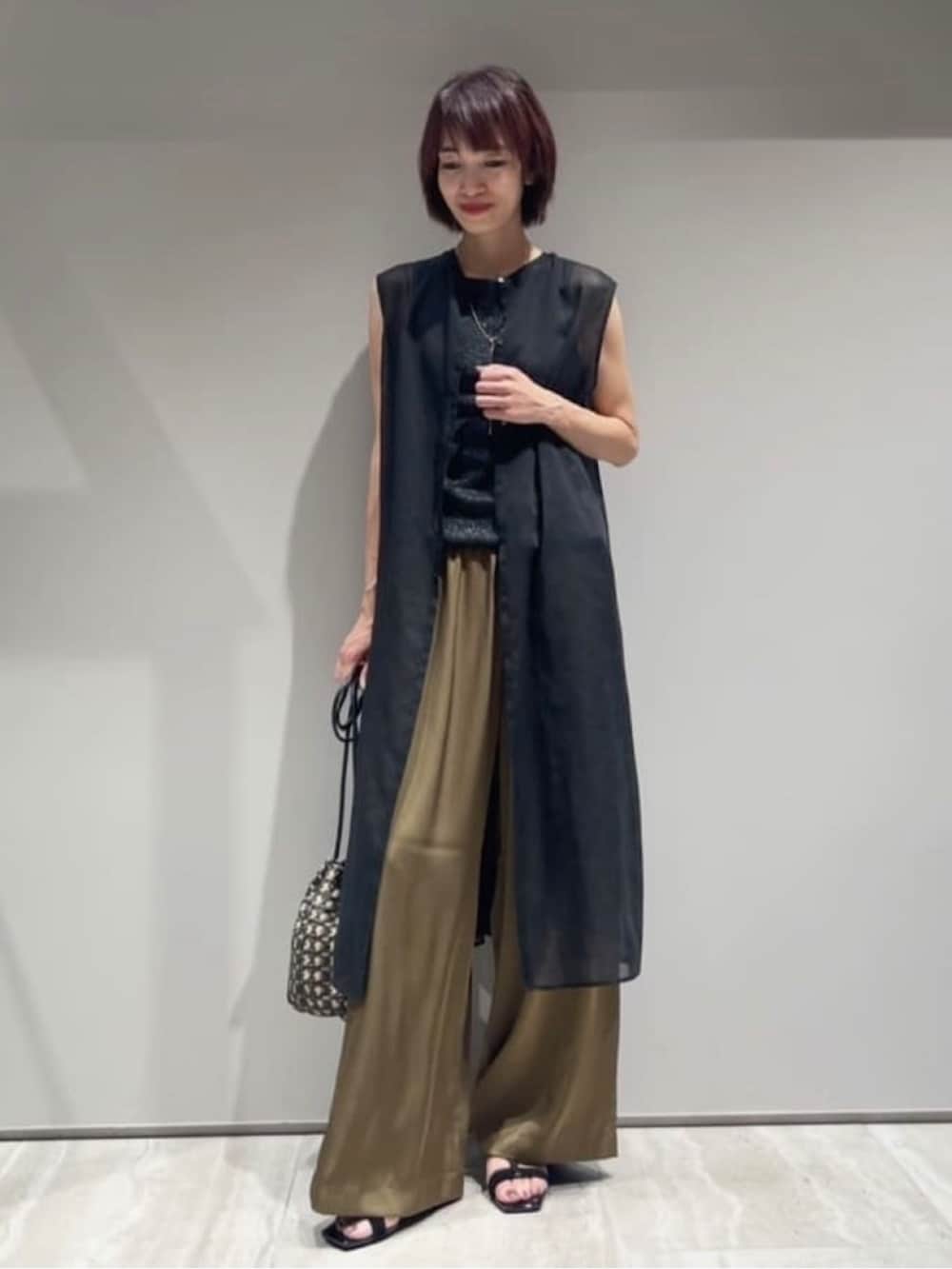 グリーン系のその他パンツ、ブラック系のシャツ/ブラウス、ブラック系のタンクトップを着用したレディースの春コーディネートの2枚目の写真