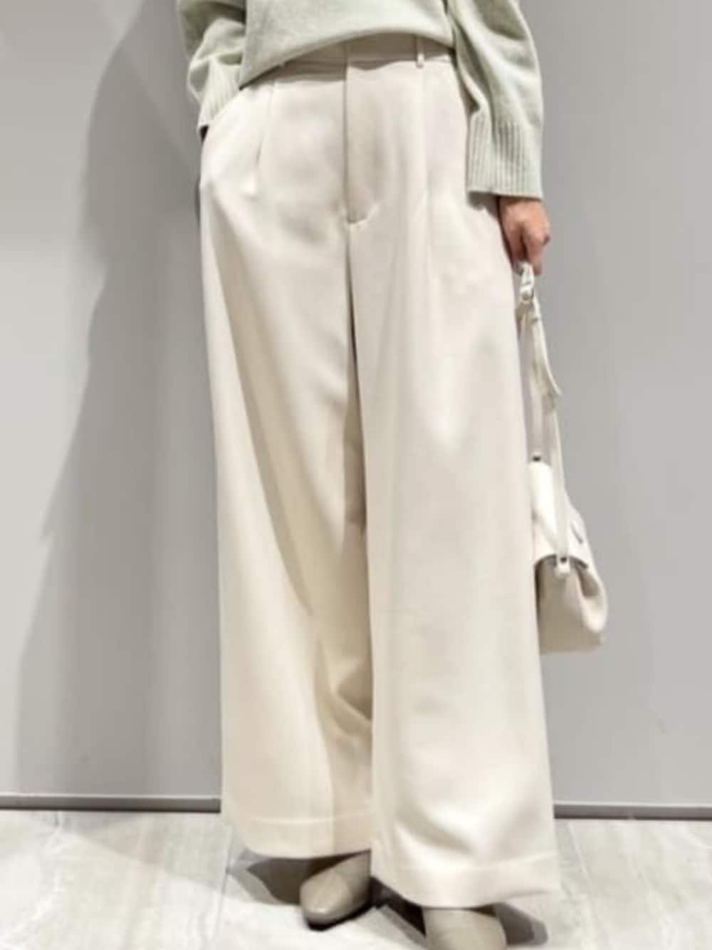 ホワイト系のその他パンツ、グリーン系のニット/セーター、ホワイト系のショルダーバッグを着用したレディースの冬コーディネートの4枚目の写真