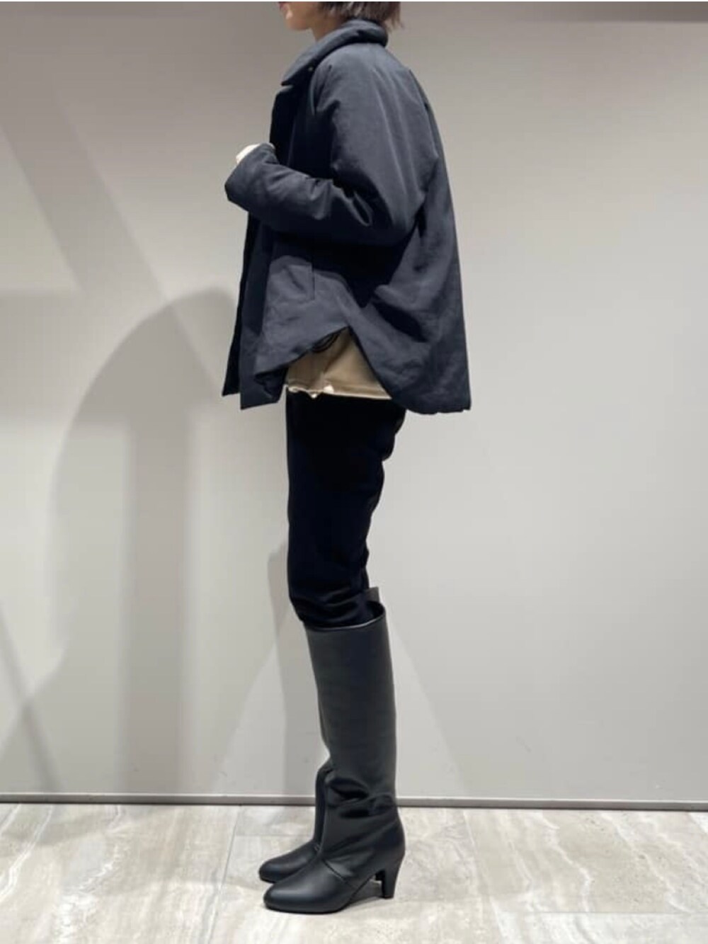 ブラック系のその他パンツ、ブラック系のダウンジャケット/コート、ベージュ系のスウェットを着用したレディースの冬コーディネートの4枚目の写真