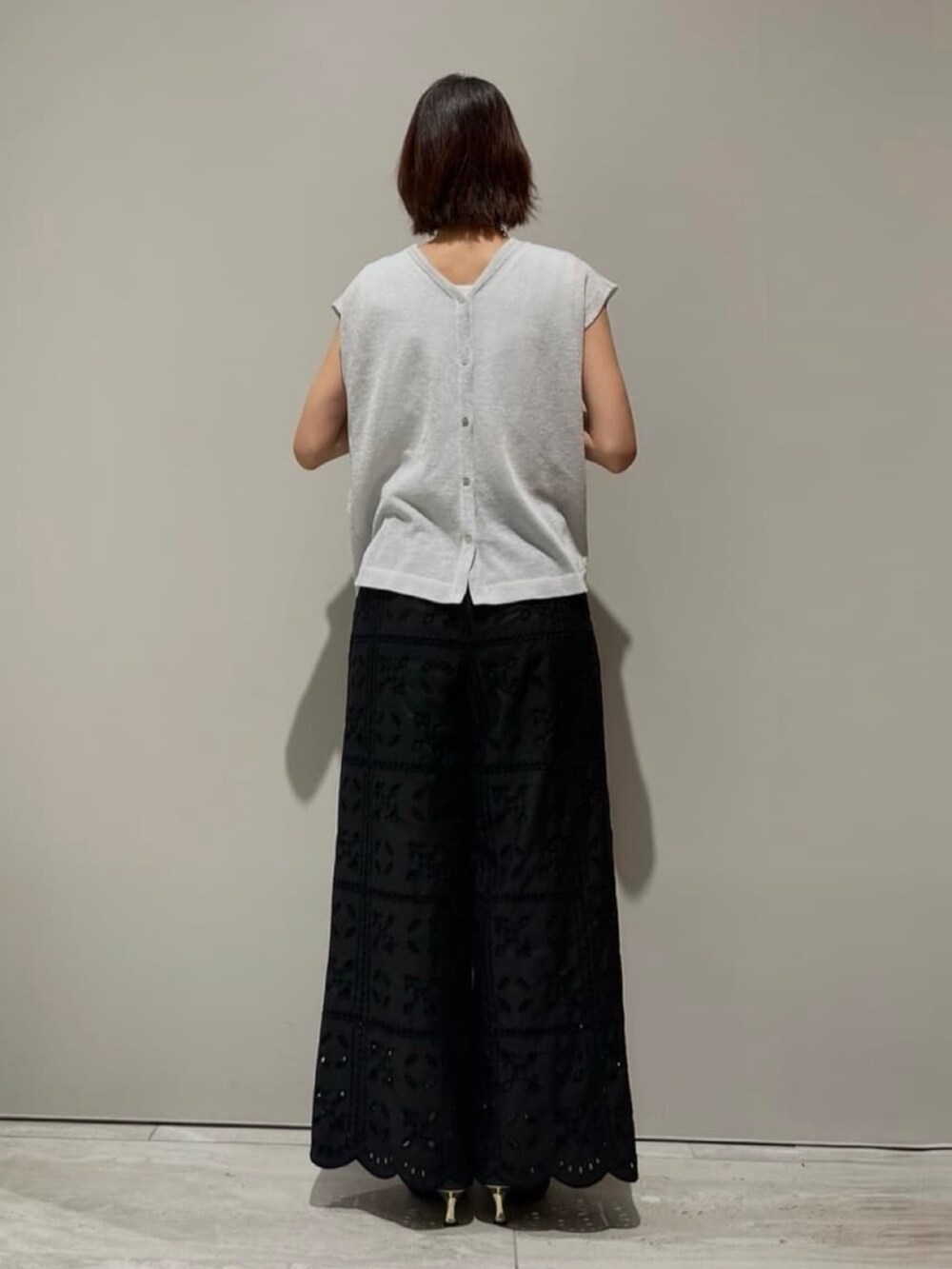 ブラック系のその他パンツ、シルバー系のタンクトップ、ホワイト系のタンクトップを着用したレディースの夏コーディネートの6枚目の写真