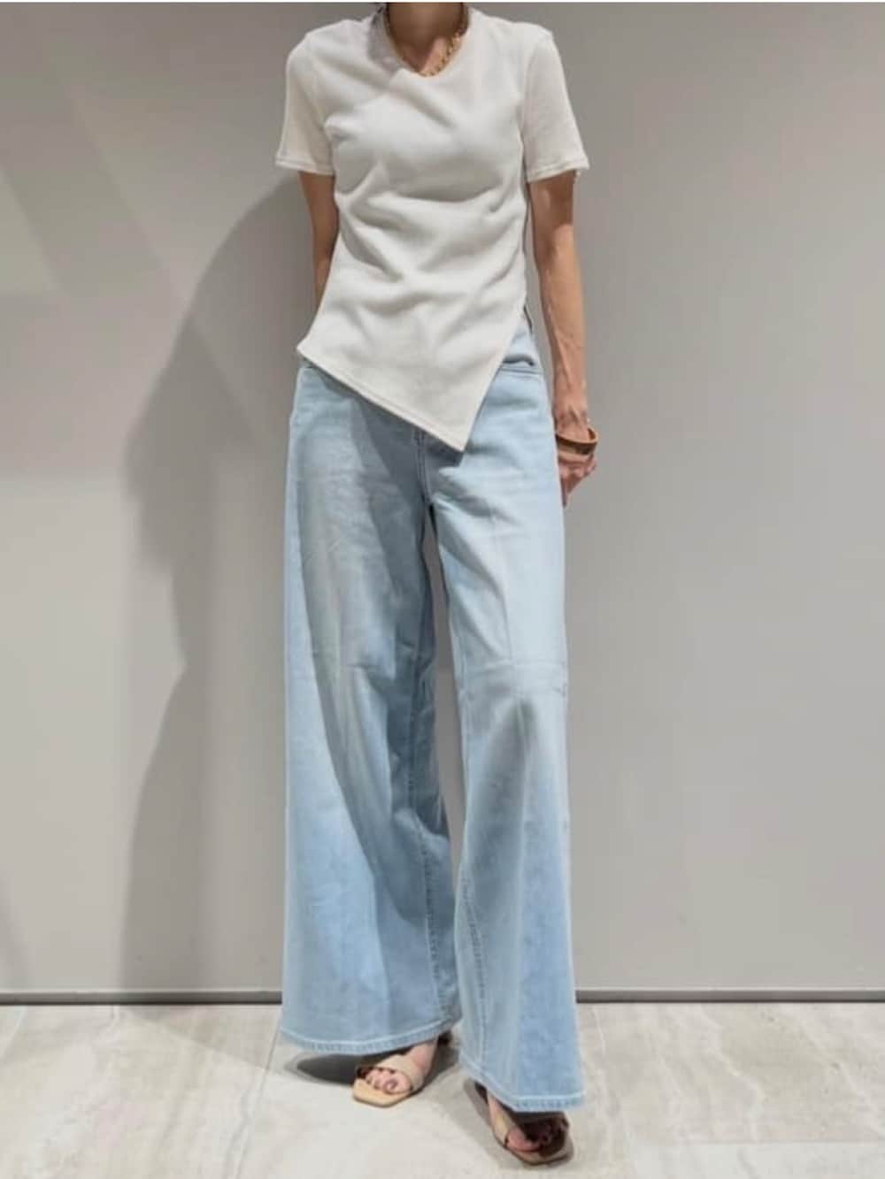 ベージュ系のテーラードジャケット、ホワイト系のTシャツ/カットソー、ブルー系のデニムパンツを着用したレディースの春コーディネートの5枚目の写真
